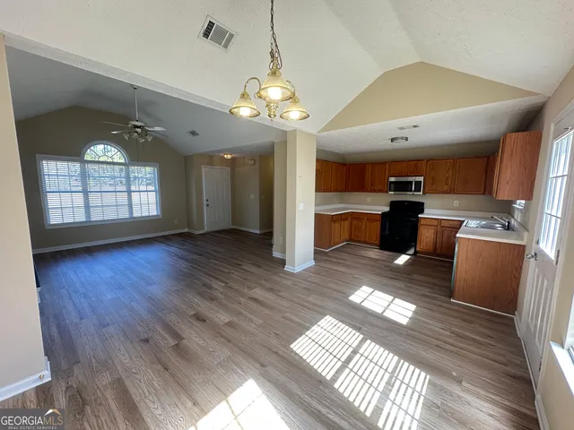 a view of a room with wooden floor and windows