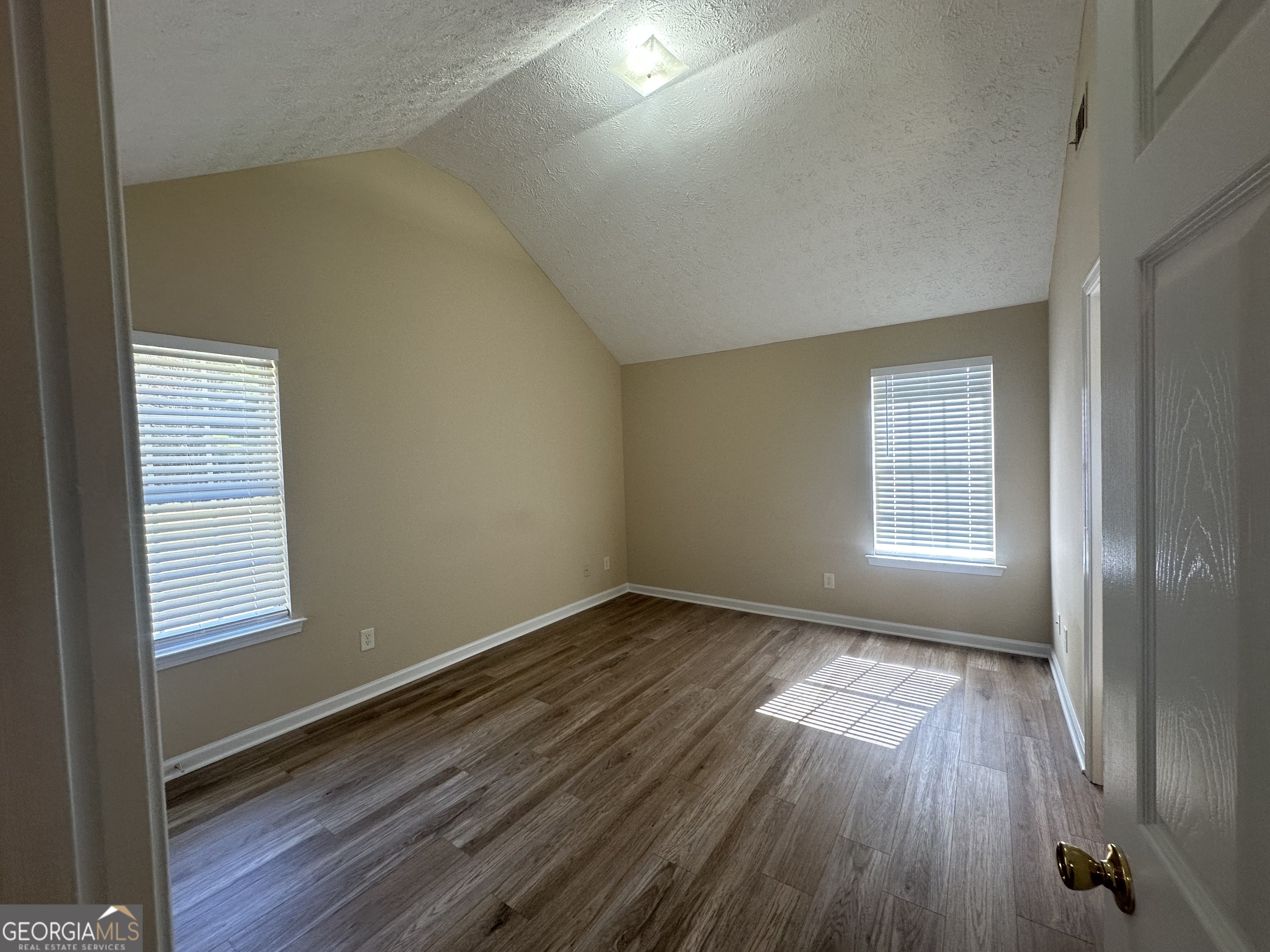 3860 Cedar Rock Road Woodbury, GA 30293 - Photo 8 of 14 an empty room with wooden floor and windows