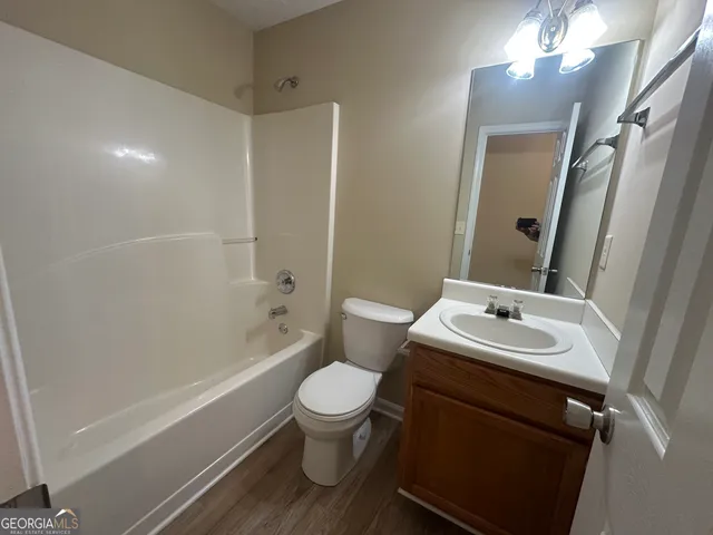 a bathroom with a sink toilet vanity and tub