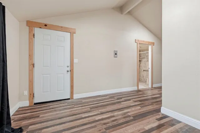 a view of empty room with wooden floor and window
