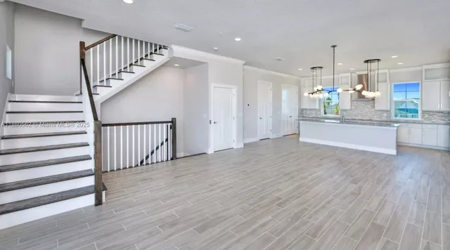 a view of a hallway with wooden floor and staircase