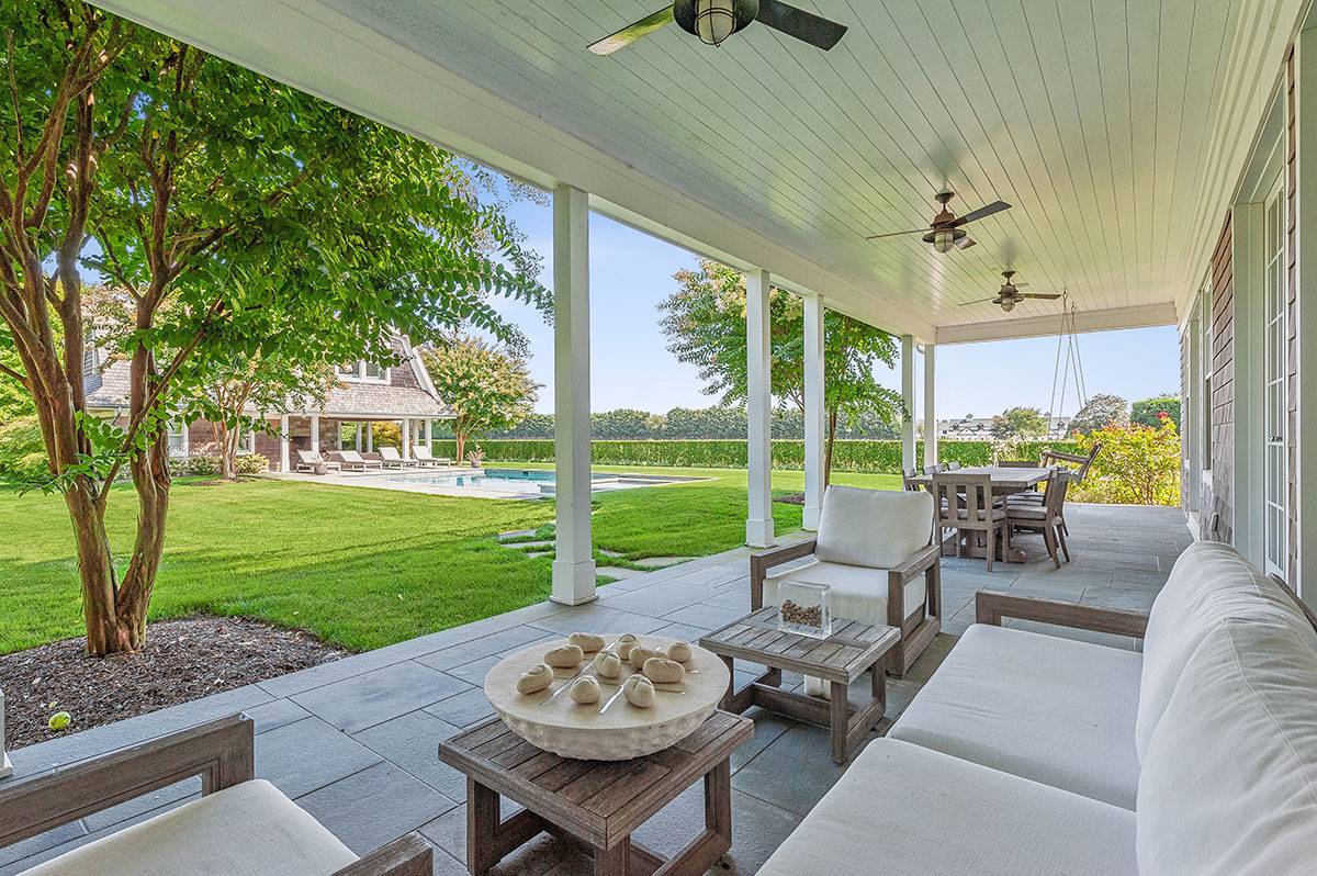 63 Newlight Lane Bridgehampton, NY 11976 - Photo 27 of 37 a view of a patio with couches potted plants and a big yard
