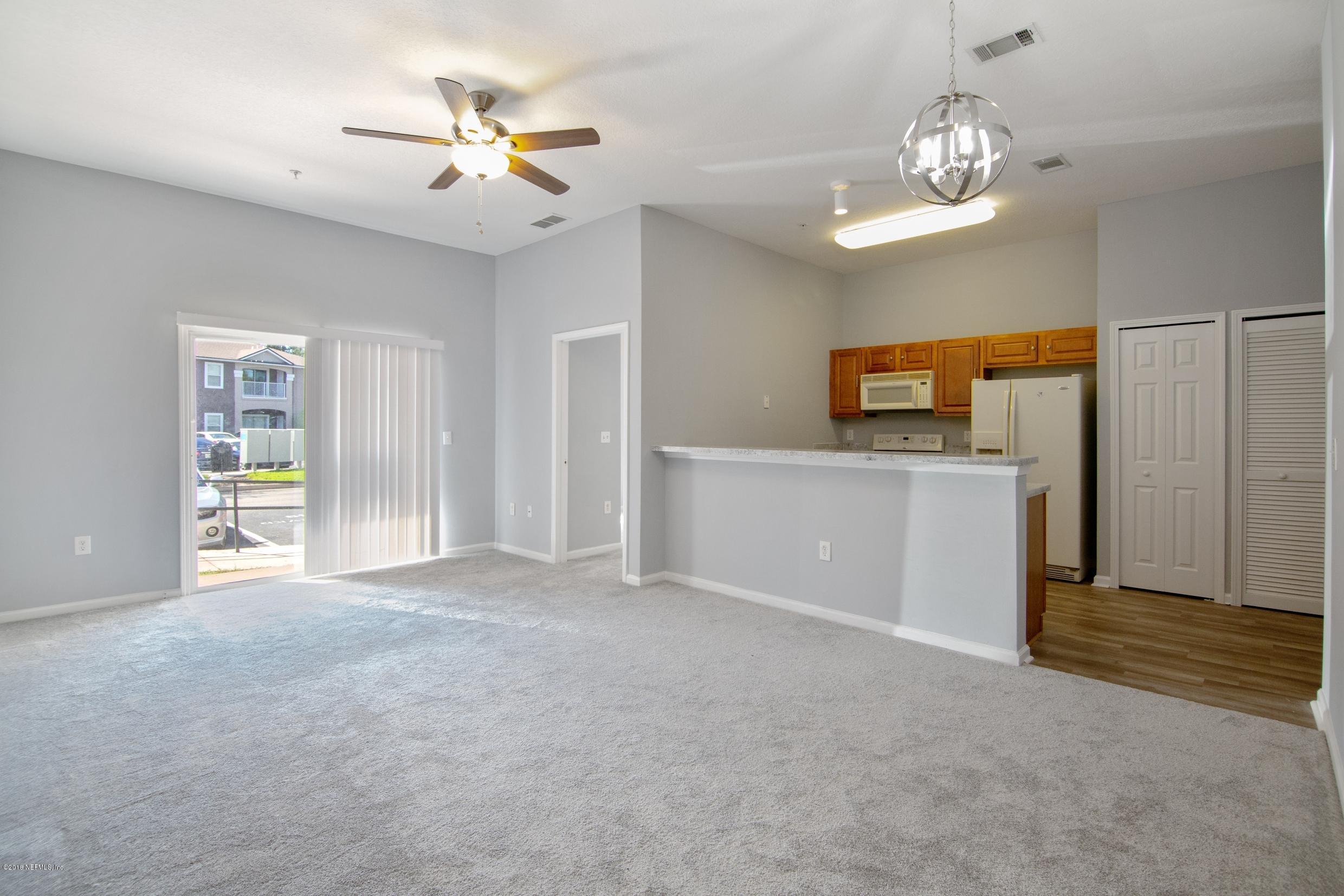 7920 Merrill Road, Unit 605 Jacksonville, FL 32277 - Photo 4 of 24 a view of a kitchen with a sink and a chandelier