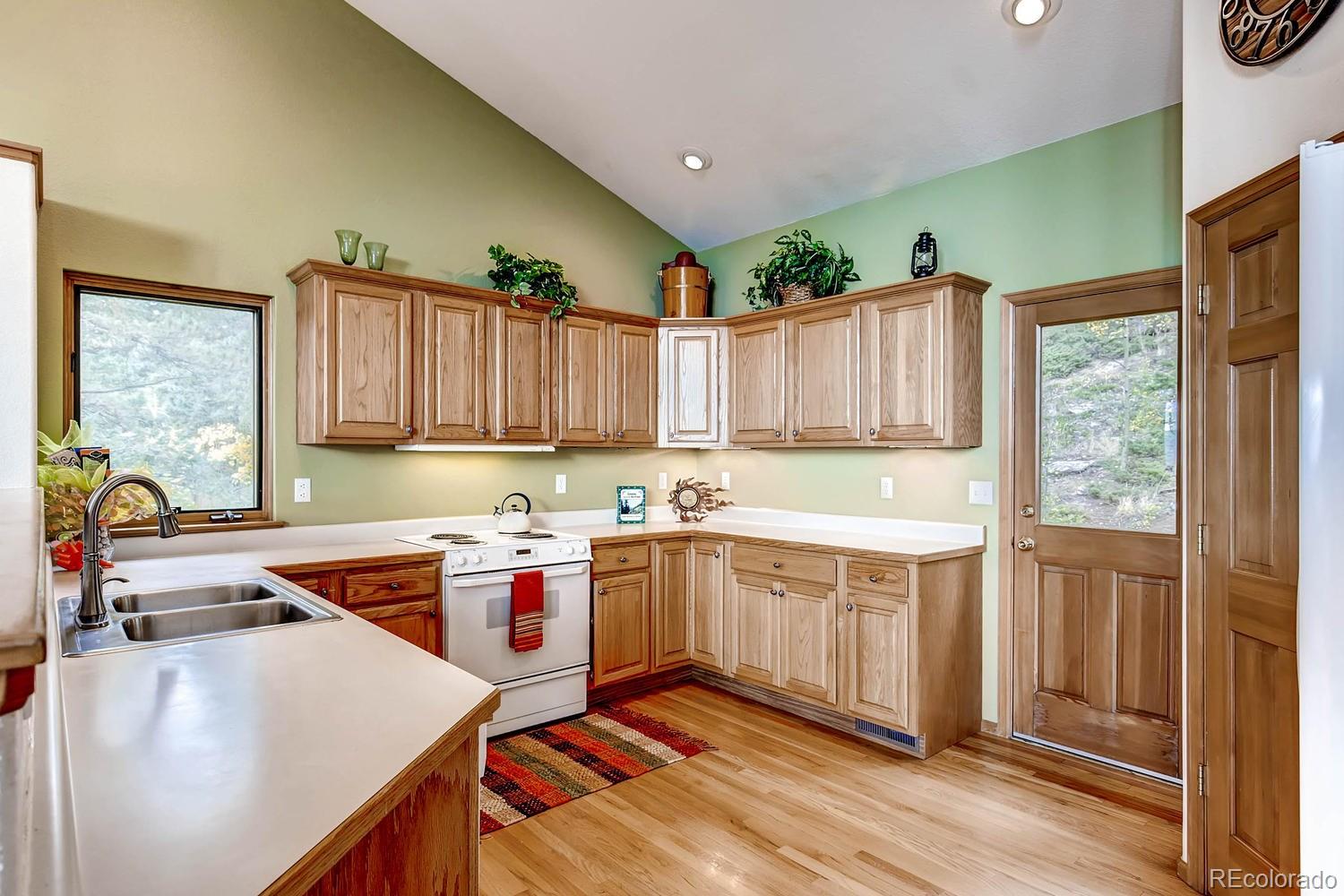 11760 Baca Road Conifer, CO 80433 - Photo 11 of 24 a kitchen with a stove a sink and a refrigerator