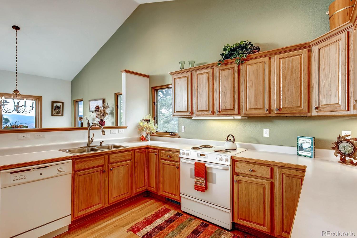 11760 Baca Road Conifer, CO 80433 - Photo 12 of 24 a utility room with stainless steel appliances granite countertop a sink dishwasher stove and cabinets with wooden floor