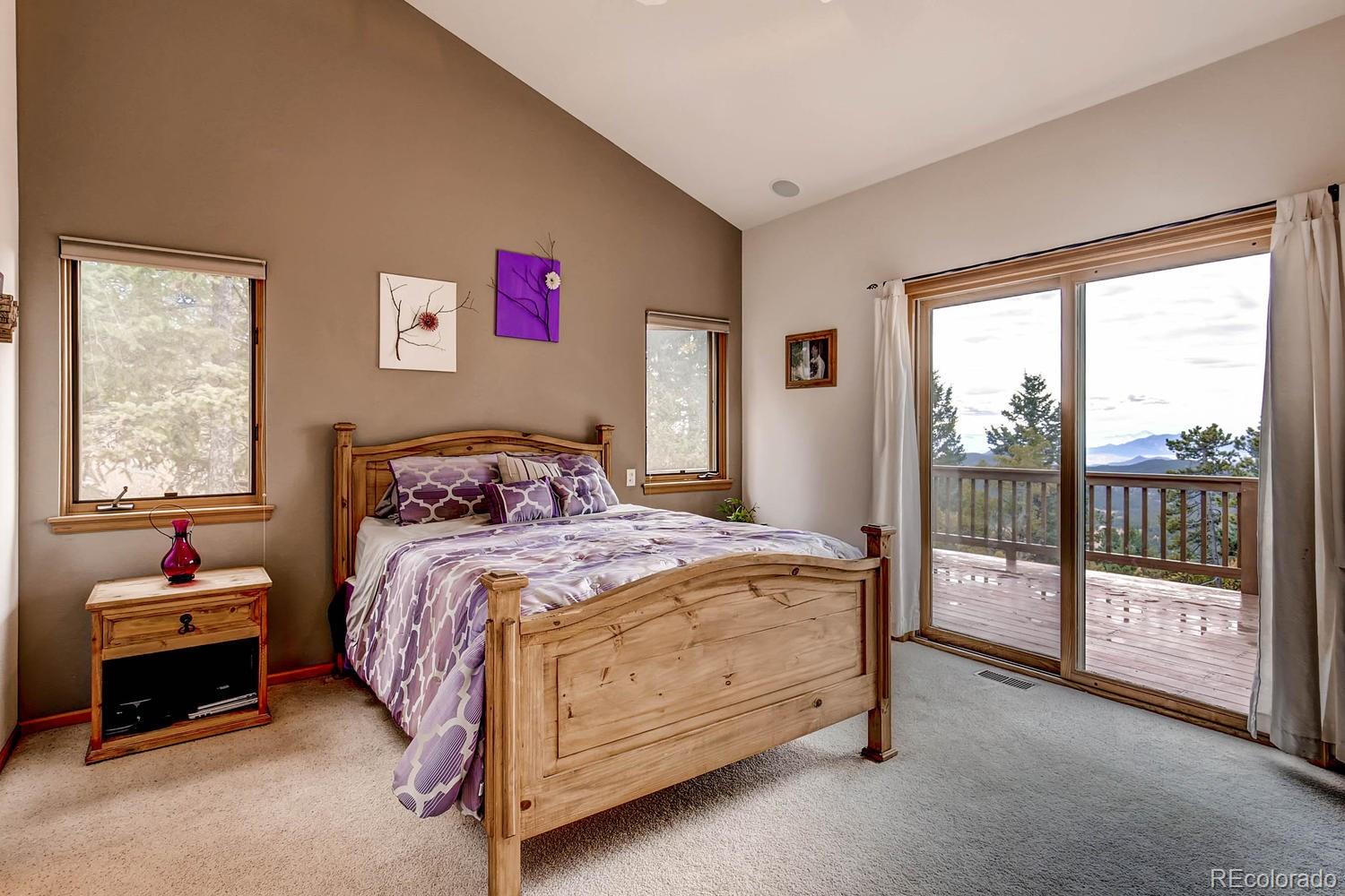 11760 Baca Road Conifer, CO 80433 - Photo 13 of 24 a bedroom with a bed and glass door