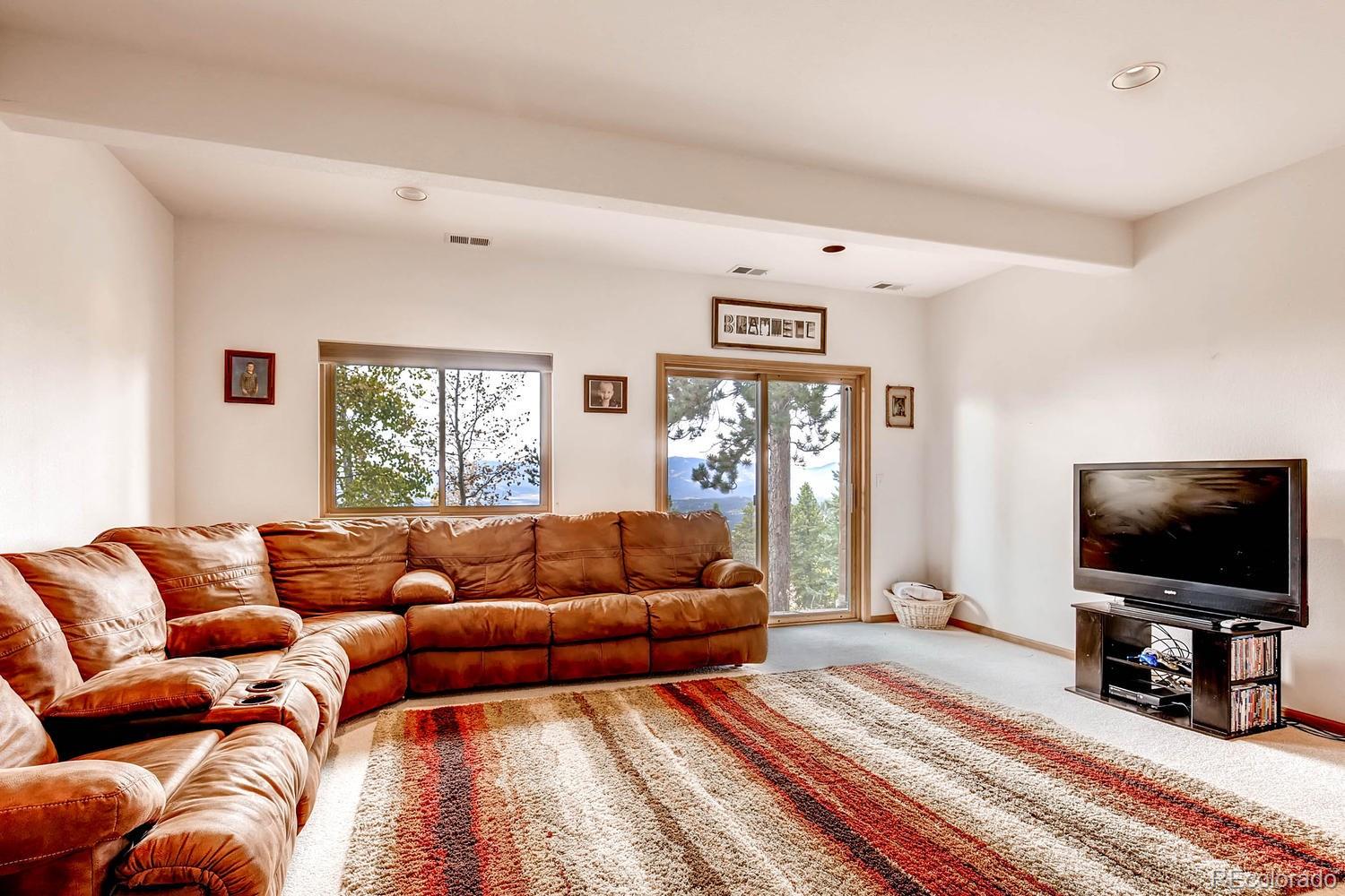11760 Baca Road Conifer, CO 80433 - Photo 16 of 24 a living room with furniture and a flat screen tv
