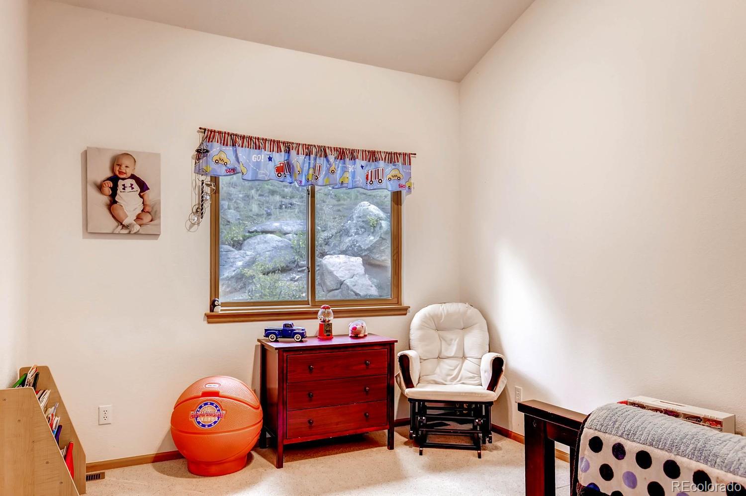 11760 Baca Road Conifer, CO 80433 - Photo 21 of 24 a view of a bedroom with furniture and natural light
