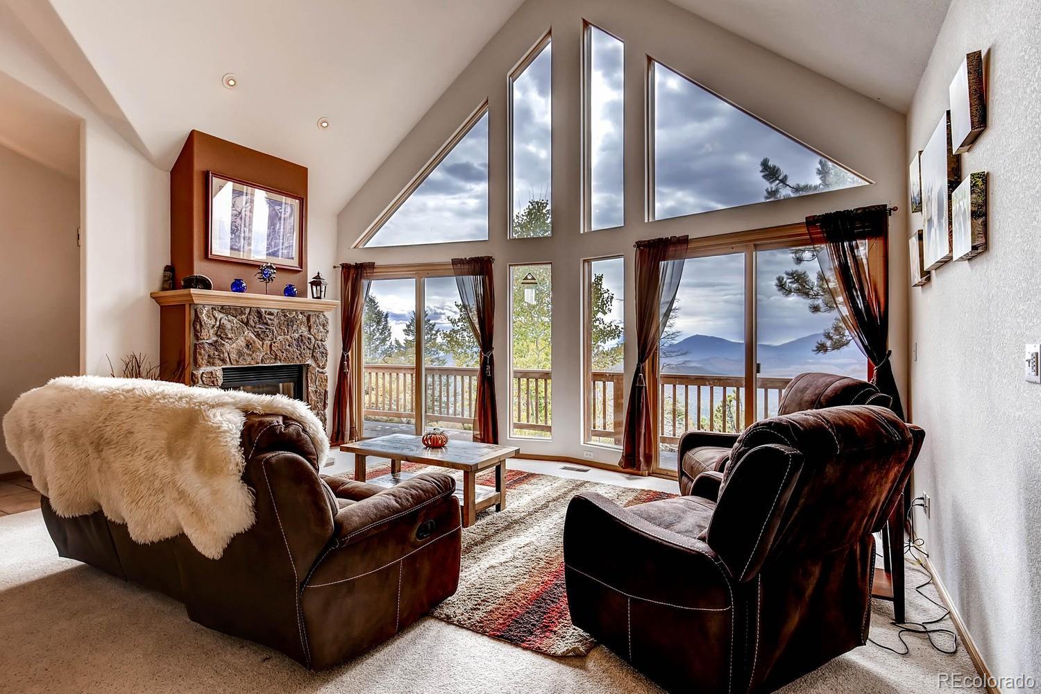 11760 Baca Road Conifer, CO 80433 - Photo 5 of 24 a living room with furniture fireplace and a large window
