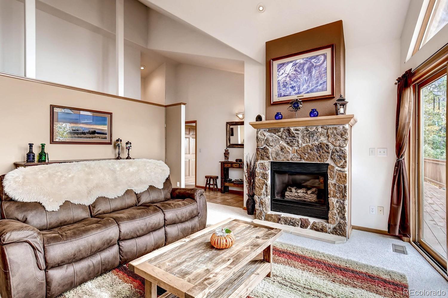 11760 Baca Road Conifer, CO 80433 - Photo 6 of 24 a living room with furniture and a fireplace
