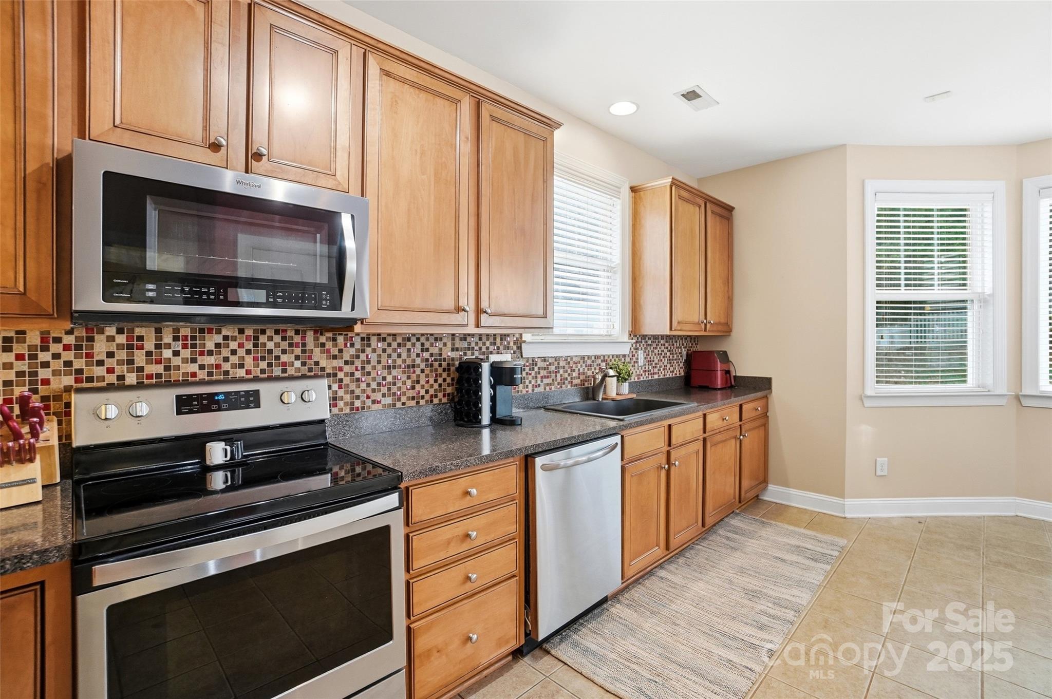 10432 Watoga Way Cornelius, NC 28031 - Photo 21 of 42 a kitchen with stainless steel appliances a stove sink microwave and cabinets