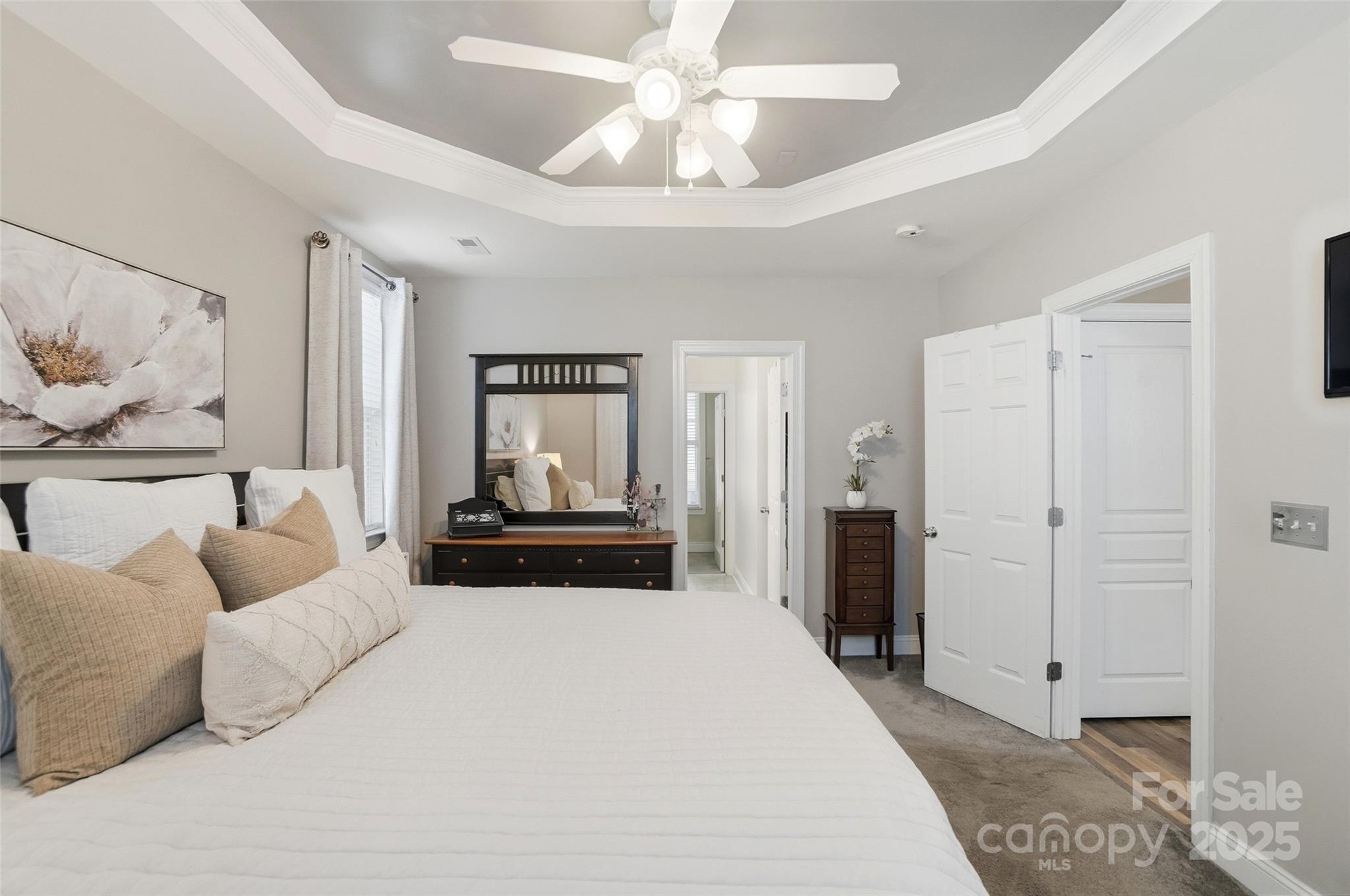 10432 Watoga Way Cornelius, NC 28031 - Photo 26 of 42 a bedroom with a large bed and a chandelier