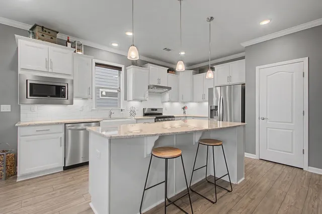 a kitchen with stainless steel appliances granite countertop a sink stove and cabinets