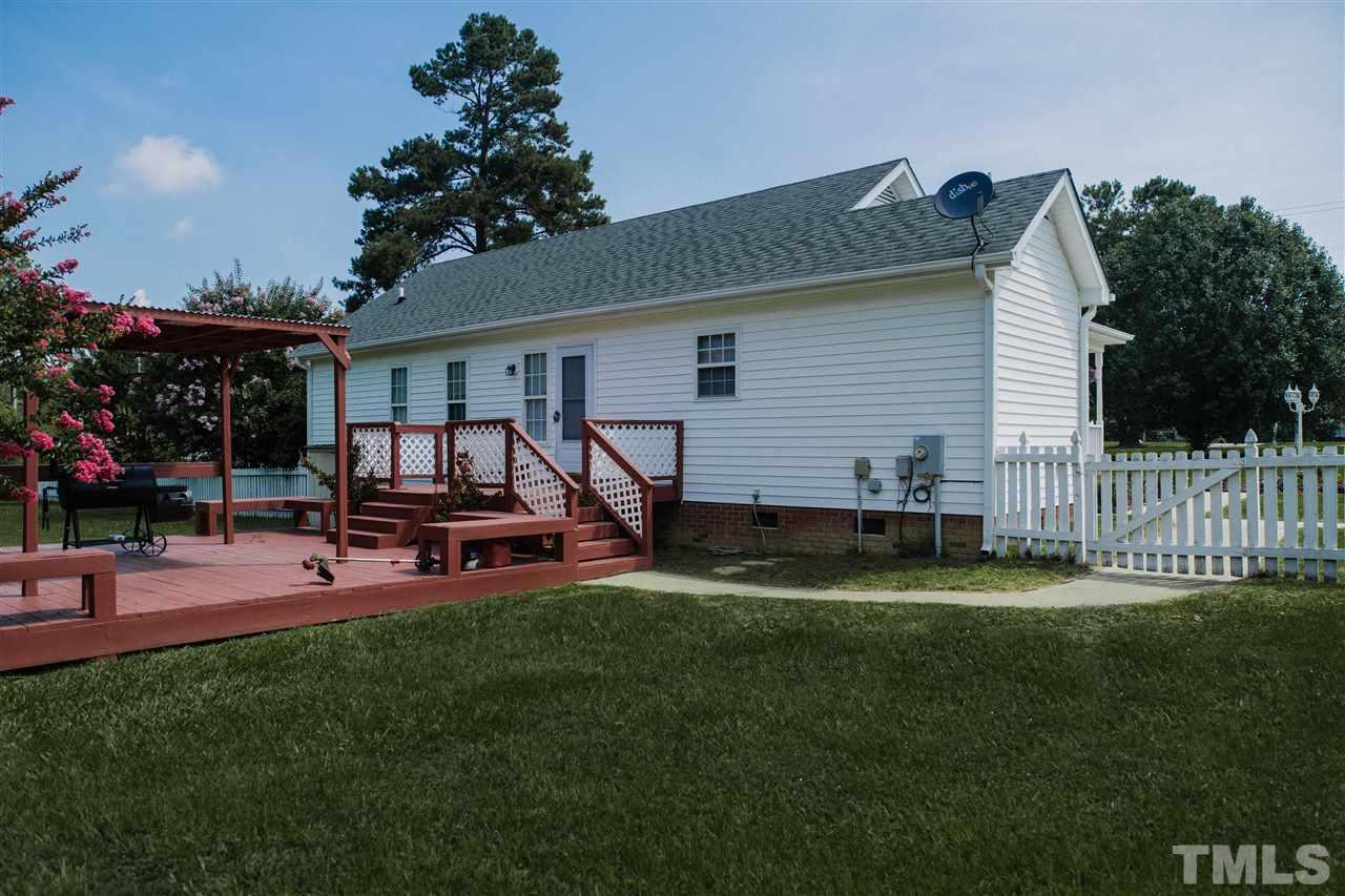 7244 Turner Fish Road Willow Spring, NC 27592 - Photo 16 of 18 a view of a backyard with a patio and a garden