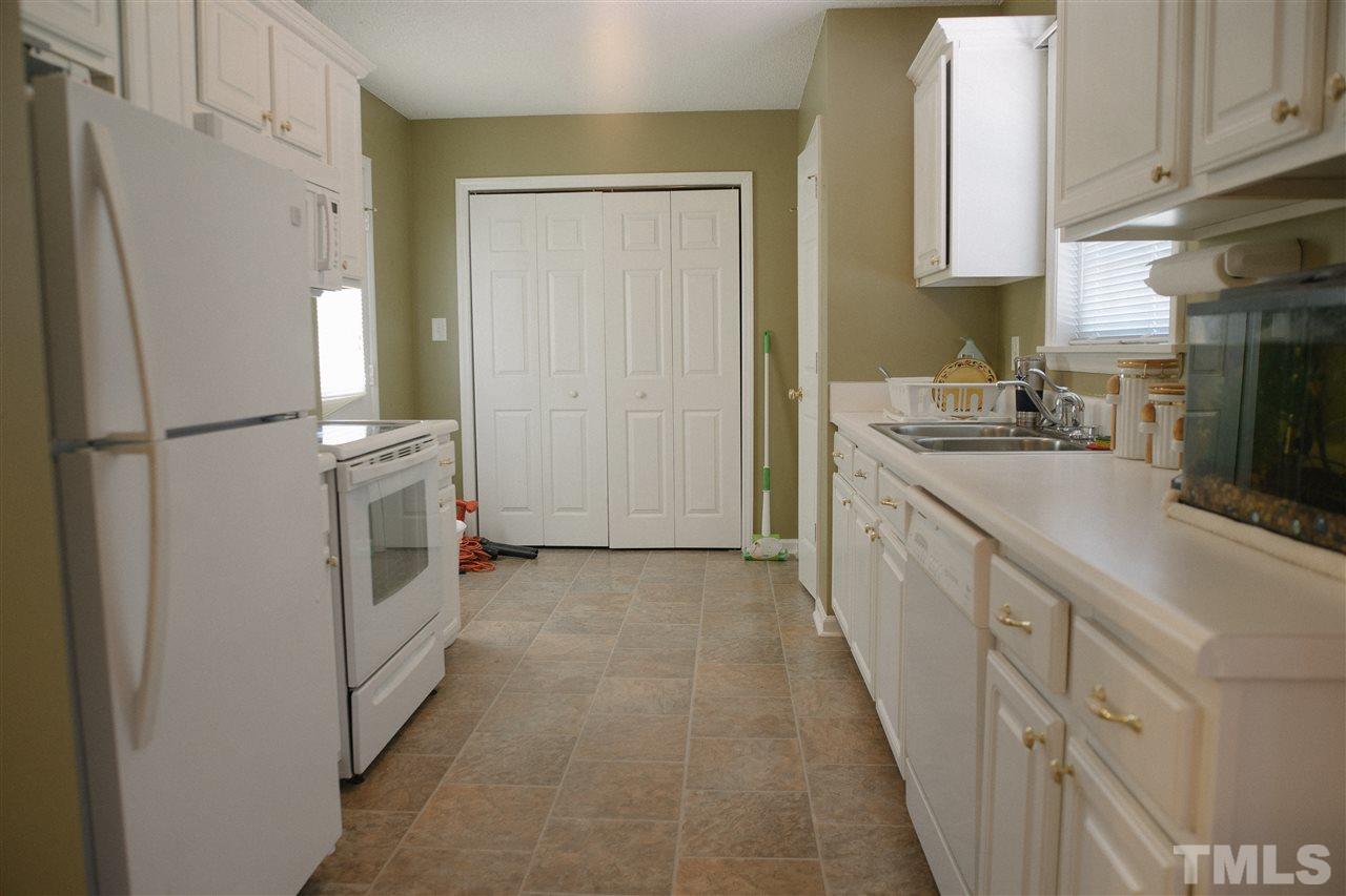 7244 Turner Fish Road Willow Spring, NC 27592 - Photo 6 of 18 a kitchen with a sink a refrigerator and cabinets