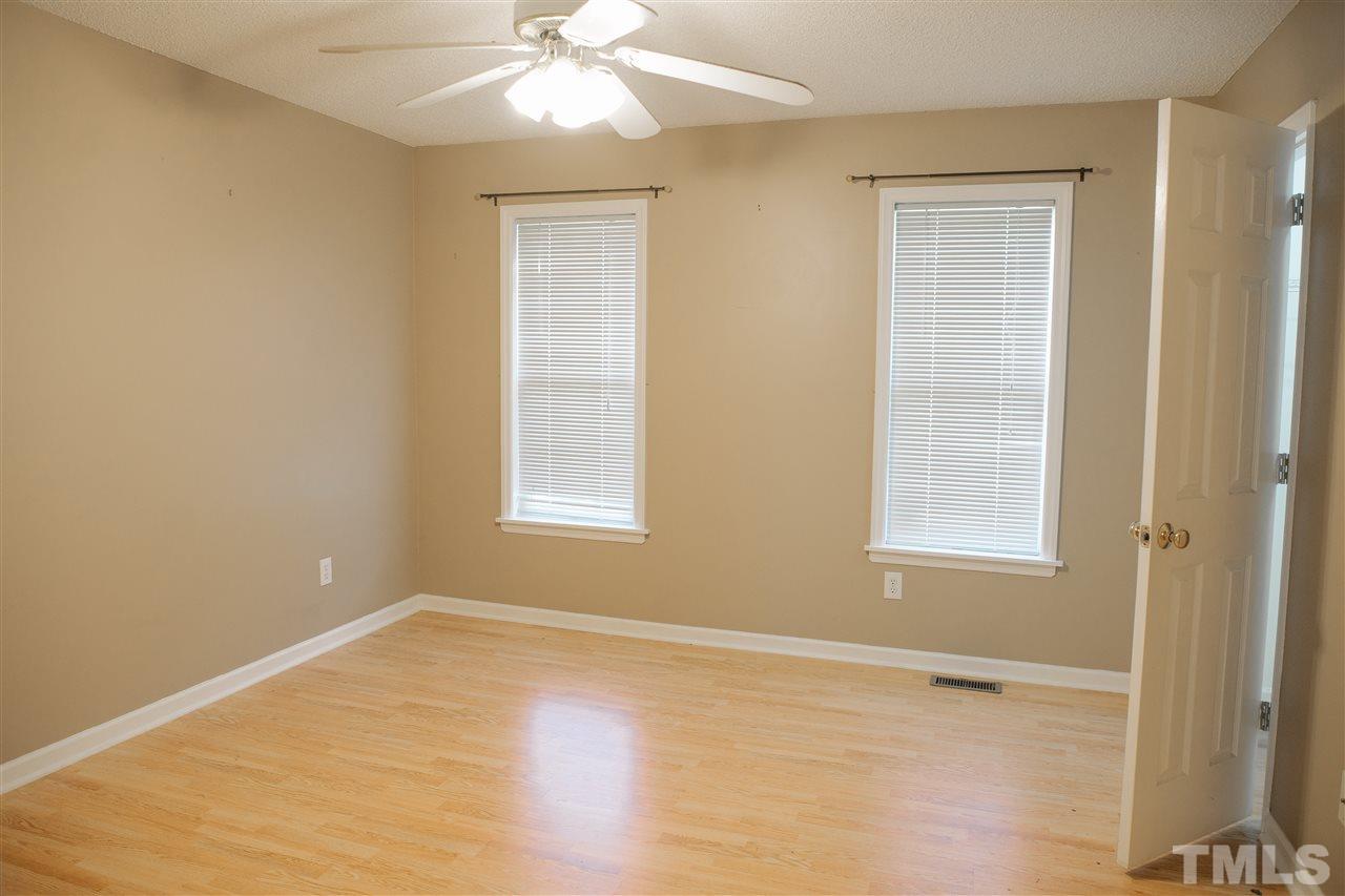 7244 Turner Fish Road Willow Spring, NC 27592 - Photo 9 of 18 a view of an empty room with wooden floor and a window