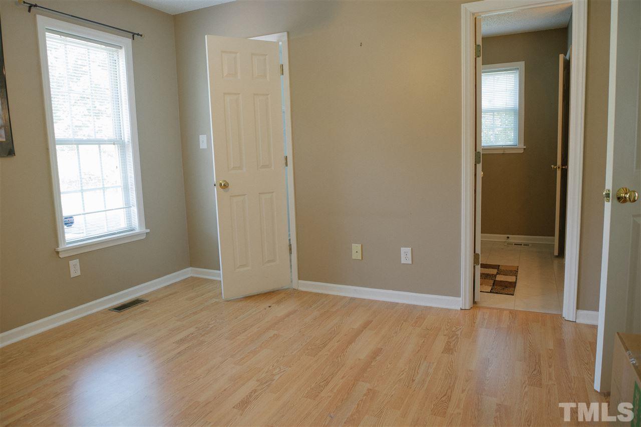 7244 Turner Fish Road Willow Spring, NC 27592 - Photo 10 of 18 an empty room with wooden floor and windows