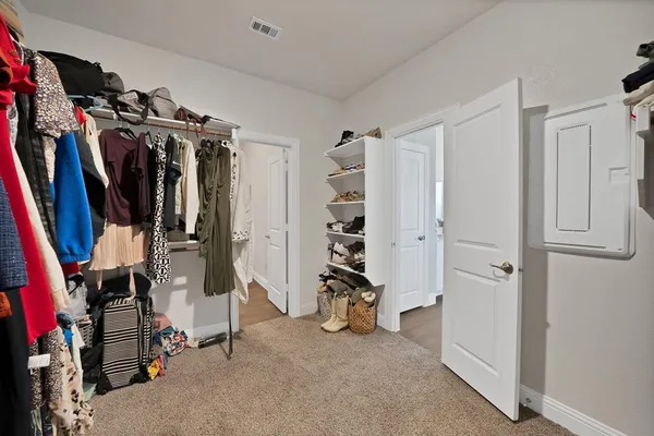 a view of walk in closet with clothes and shoes