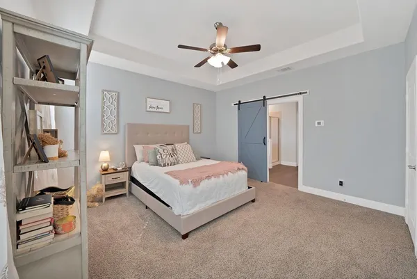 a spacious bedroom with a bed and a chandelier