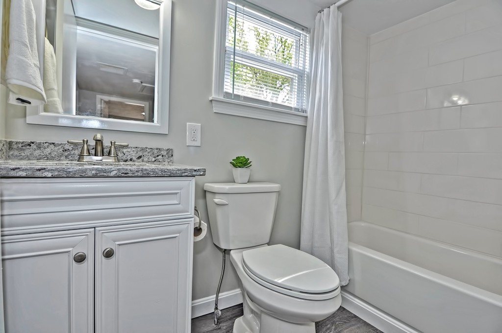 65 Edgewater Avenue Shrewsbury, MA 01545 - Photo 13 of 24 a bathroom with a granite countertop toilet a sink and a bathtub