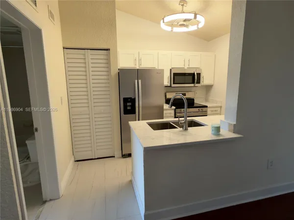 a kitchen with stainless steel appliances granite countertop a sink and refrigerator