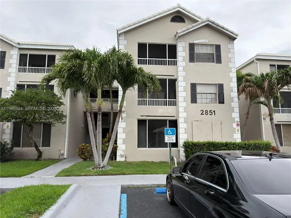 a view of a white house with a yard and plants
