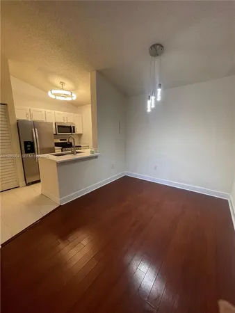 a view of a kitchen with a sink stove cabinets and empty room