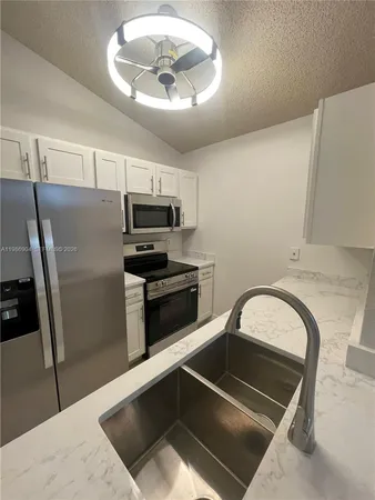 a kitchen with a refrigerator and a stove top oven