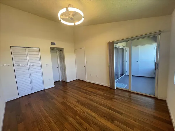 a view of empty room with wooden floor
