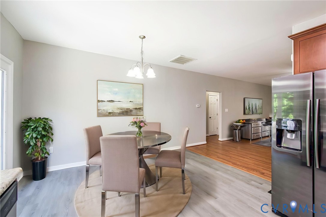 1297 Manfield Road Aylett, VA 23009 - Photo 5 of 41 a view of a dining room with furniture wooden floor and a chandelier
