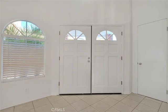an empty room with windows and ceiling fan