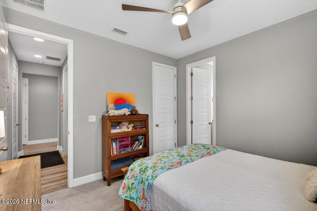 12 Wards Ravine Way St. Johns, FL 32259 - Photo 23 of 73 a bedroom with a bed and a chandelier