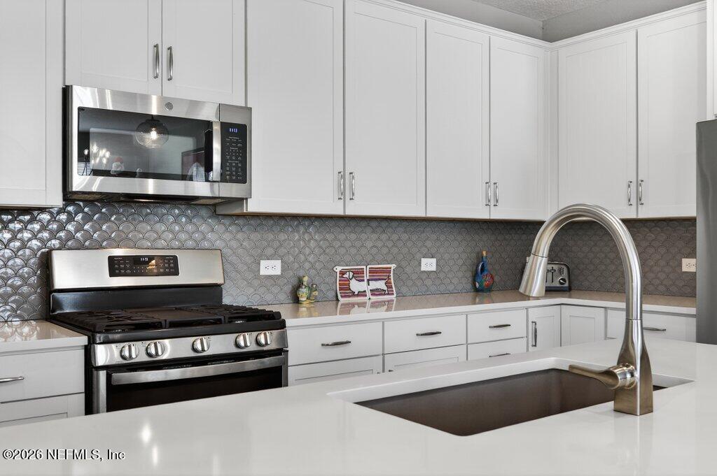 12 Wards Ravine Way St. Johns, FL 32259 - Photo 31 of 73 a kitchen with stainless steel appliances a stove a microwave a sink and cabinets
