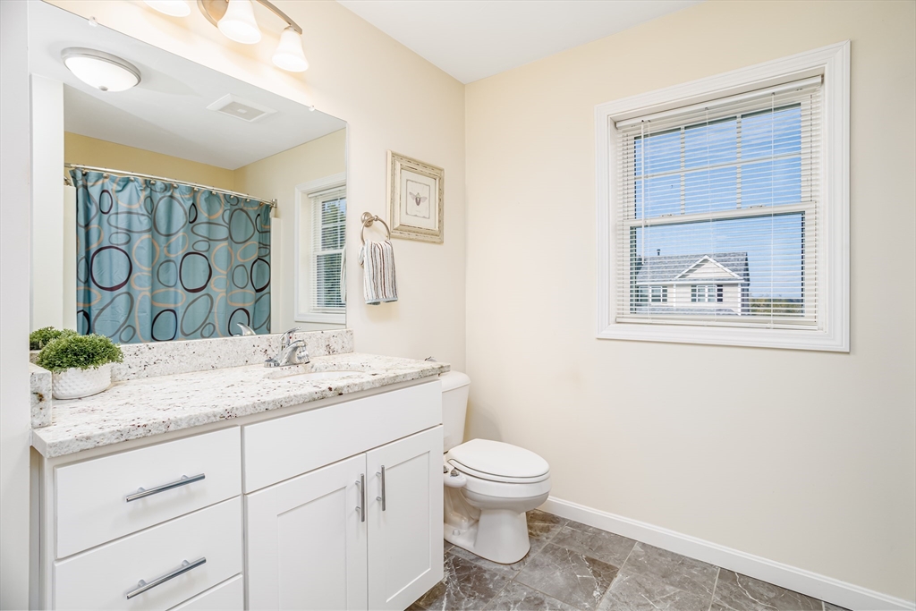1221 Hazelwood Way, Unit 1221 Clinton, MA 01510 - Photo 27 of 42 a bathroom with a granite countertop sink mirror vanity and toilet