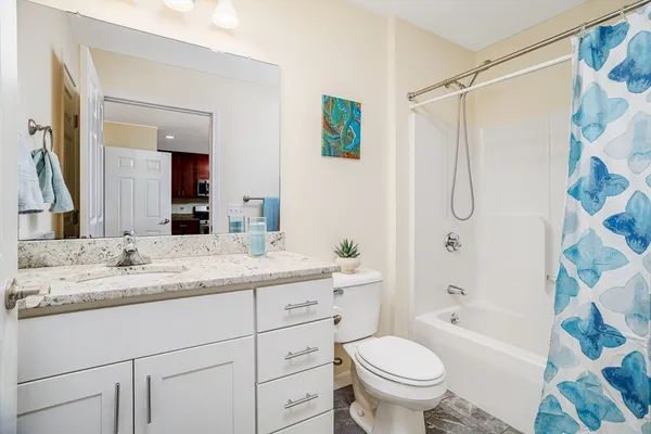 a bathroom with a granite countertop sink toilet and shower