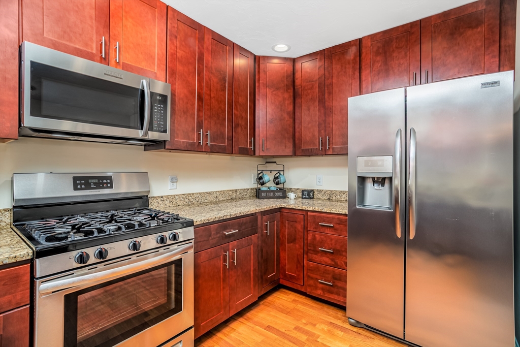 1221 Hazelwood Way, Unit 1221 Clinton, MA 01510 - Photo 6 of 42 a kitchen with stainless steel appliances granite countertop a stove microwave refrigerator and sink