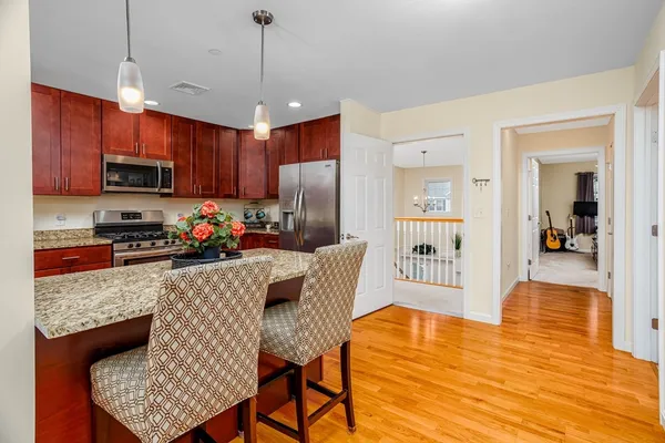 a kitchen with stainless steel appliances granite countertop a refrigerator a stove top oven a sink dishwasher and a refrigerator