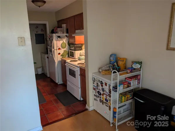 a view of a kitchen with fridge and workspace
