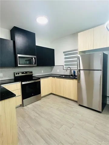 a kitchen with granite countertop a refrigerator and a stove top oven