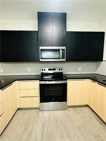 a kitchen with granite countertop a stove and a microwave