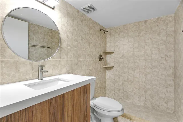 a bathroom with a sink a toilet and a mirror