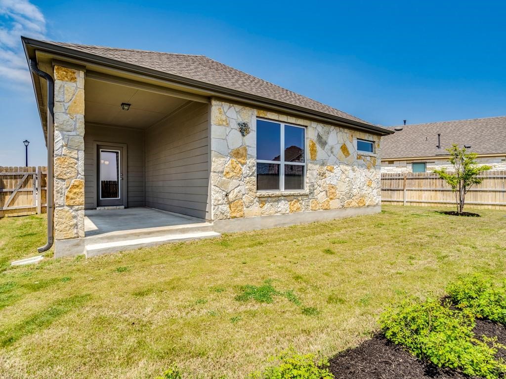 4210 Birdwatch Loop, Unit 2 Pflugerville, TX 78660 - Photo 26 of 31 A private backyard featuring a covered patio and attractive stone veneer siding.