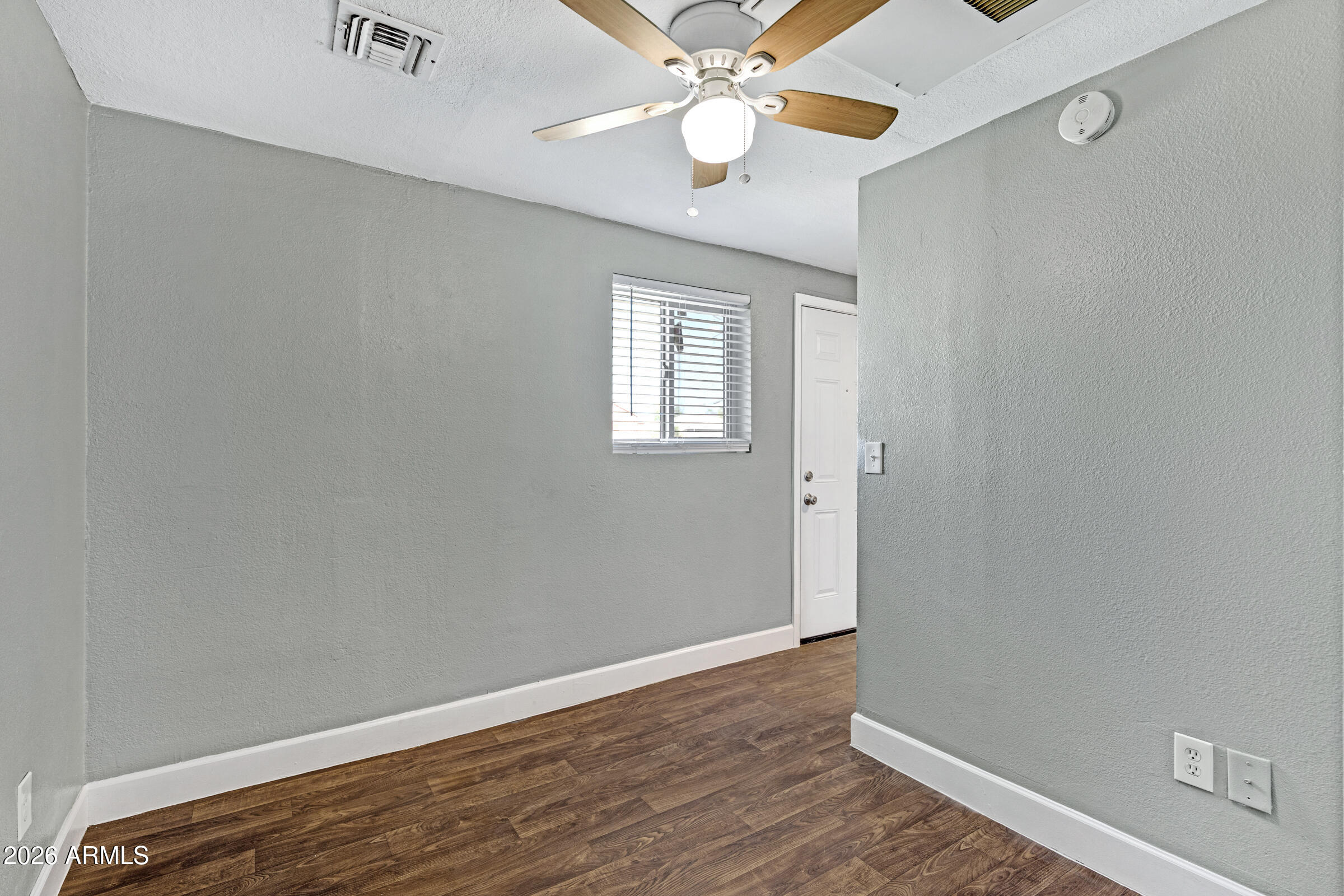 2238 East Taylor Street Phoenix, AZ 85006 - Photo 11 of 57 an empty room with wooden floor chandelier fan and windows