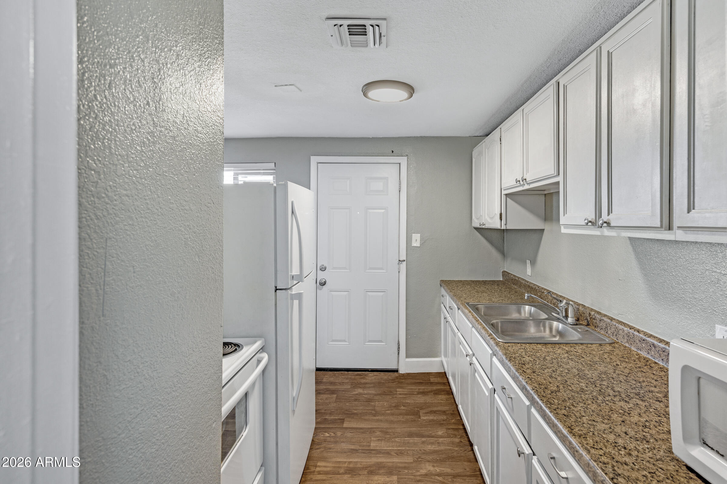 2238 East Taylor Street Phoenix, AZ 85006 - Photo 16 of 57 a kitchen with a stove a sink and cabinets