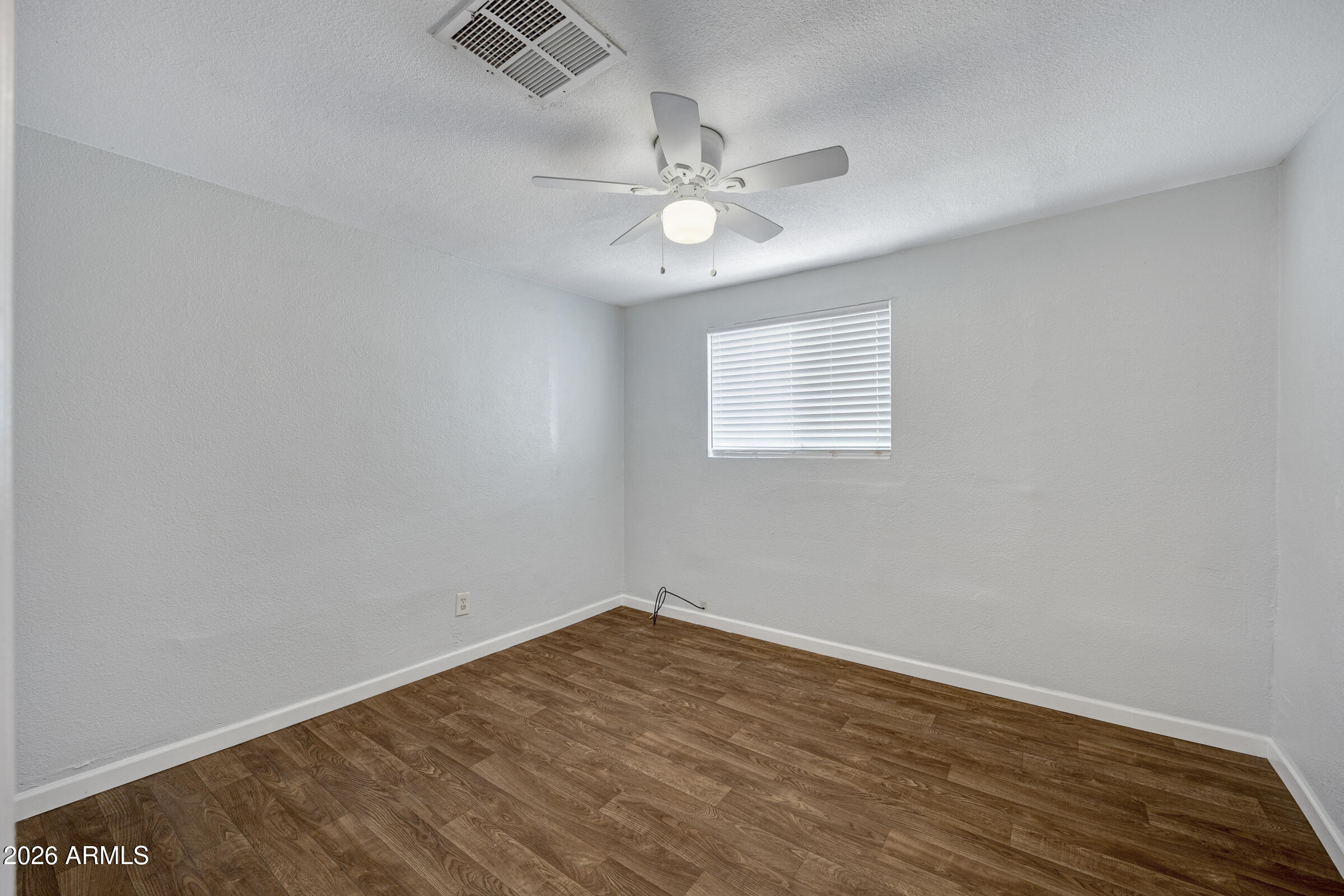 2238 East Taylor Street Phoenix, AZ 85006 - Photo 26 of 57 an empty room with wooden floor fan and windows