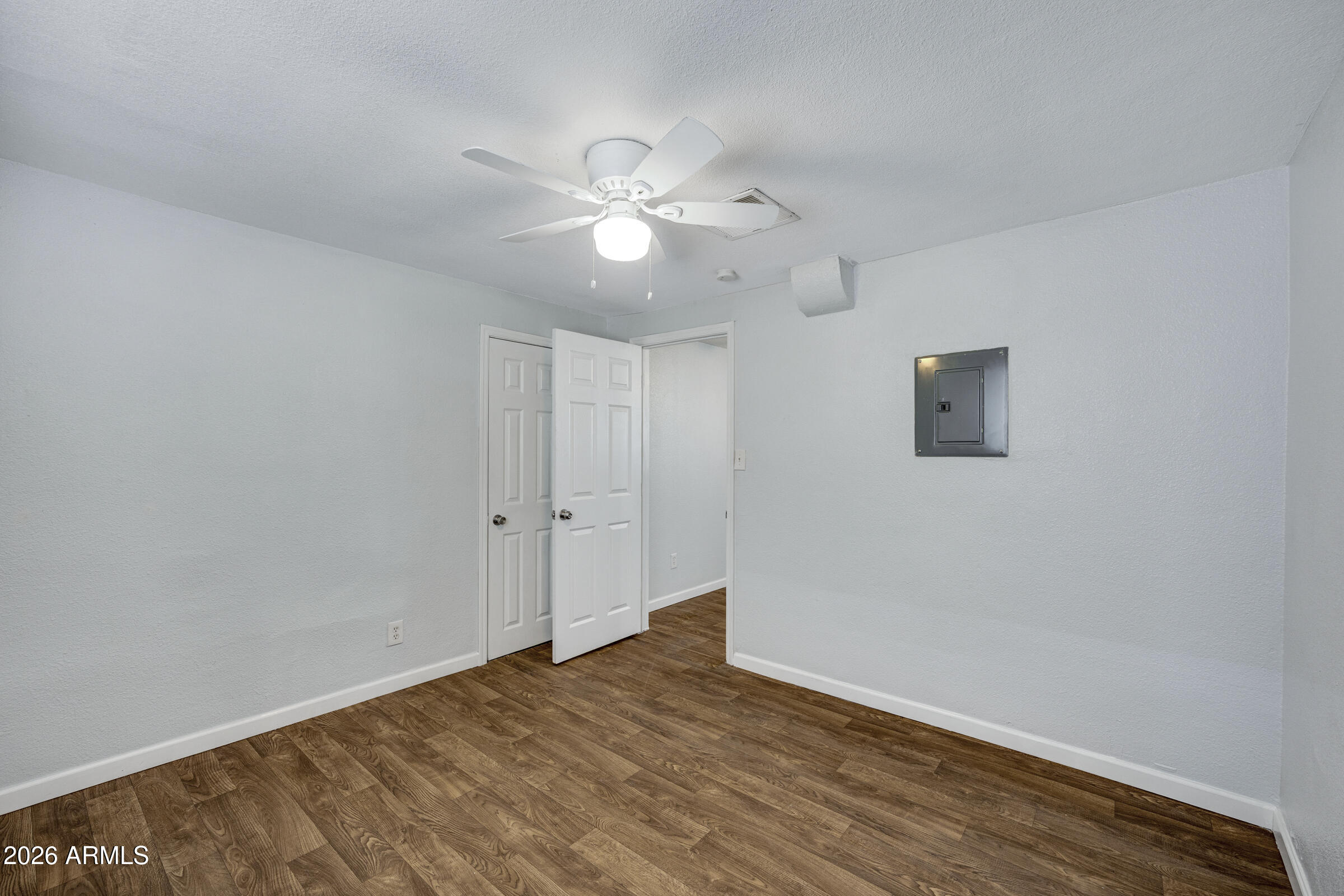 2238 East Taylor Street Phoenix, AZ 85006 - Photo 27 of 57 a view of an empty room with wooden floor and a ceiling fan