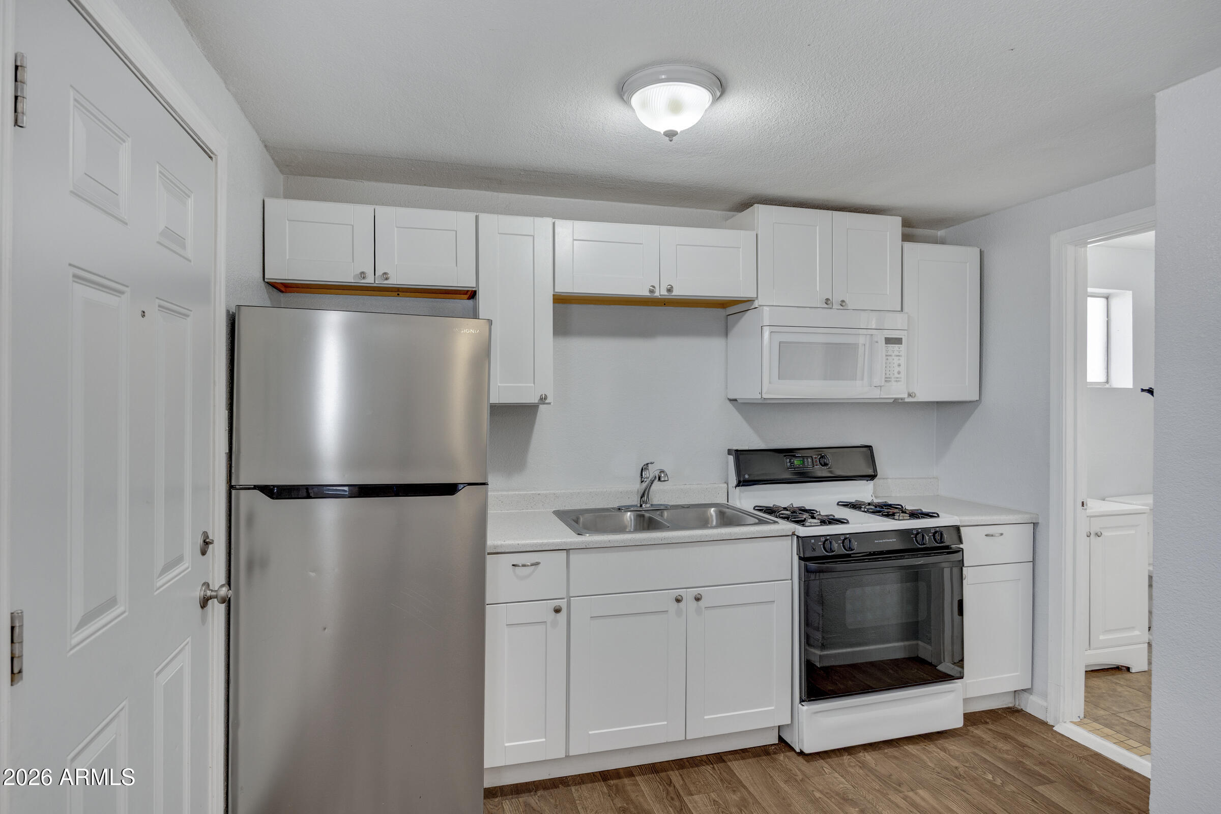2238 East Taylor Street Phoenix, AZ 85006 - Photo 28 of 57 a kitchen with a stove a refrigerator and a sink