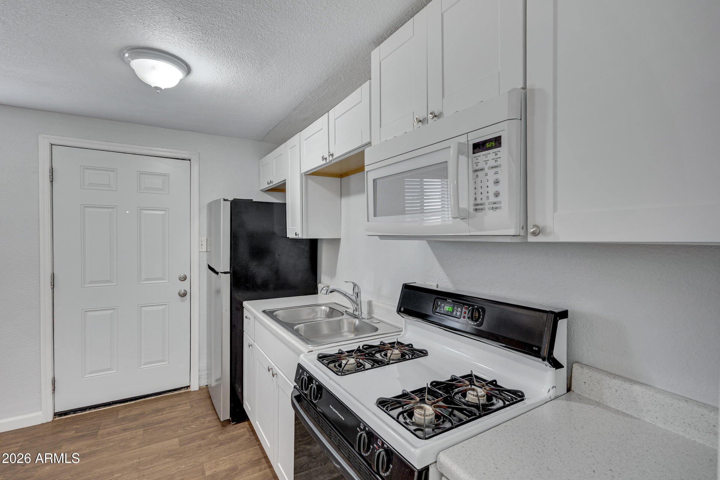 2238 East Taylor Street Phoenix, AZ 85006 - Photo 29 of 57 a kitchen with stainless steel appliances granite countertop a stove a refrigerator and a cabinets