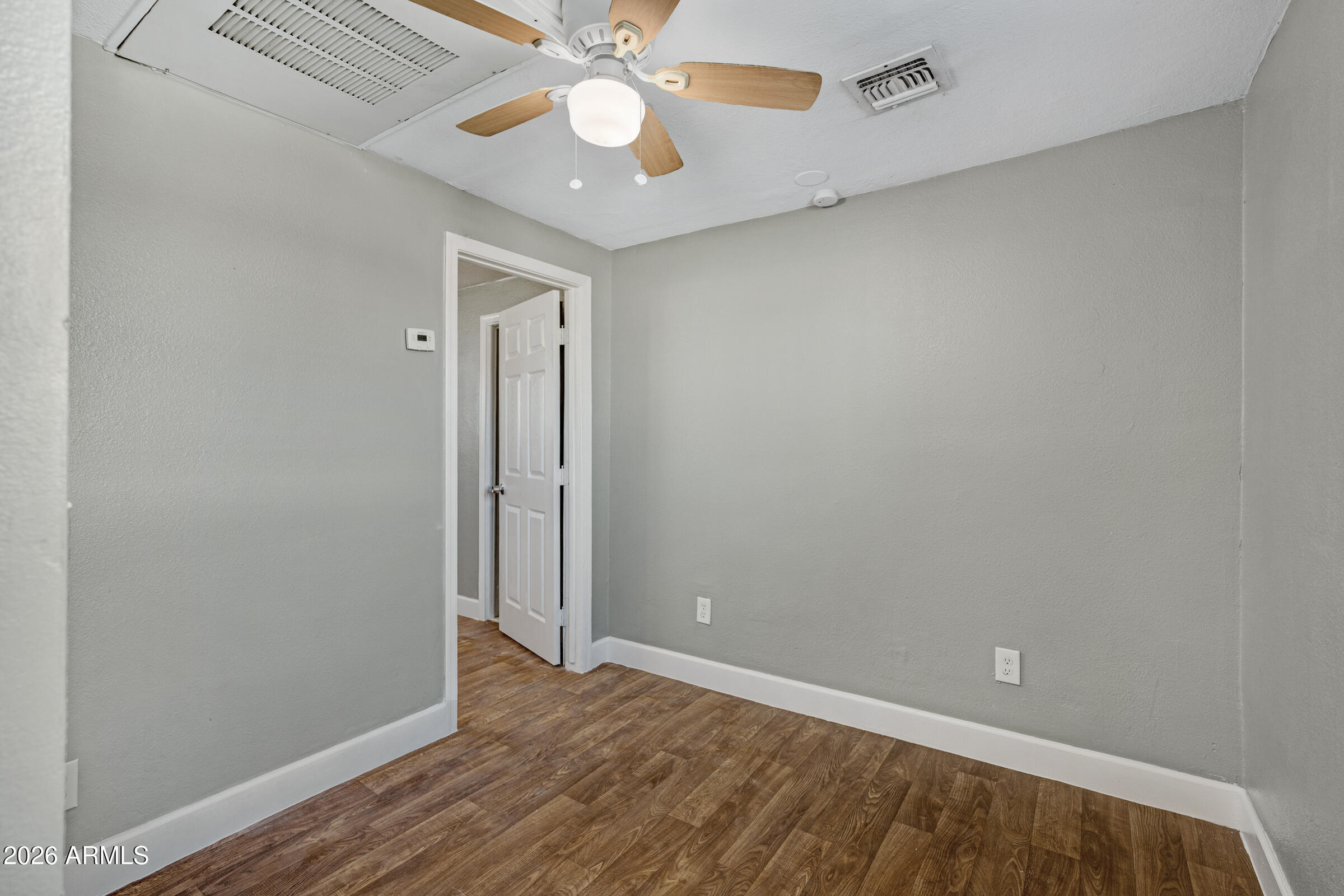 2238 East Taylor Street Phoenix, AZ 85006 - Photo 10 of 57 an empty room with wooden floor fan and windows