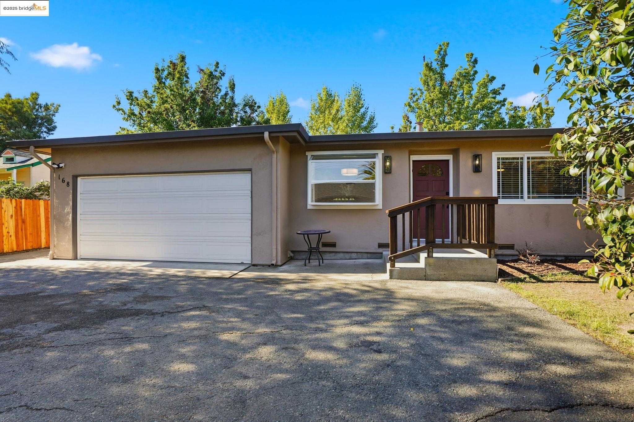 View of front of house with driveway, stucco siding, and a garage